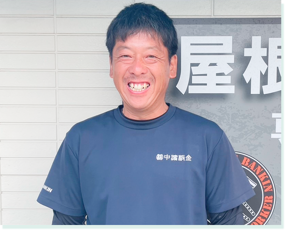 中濱板金のスタッフ・村上年誠が笑顔を見せるプロフィール写真